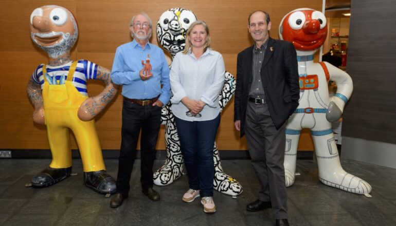 People in front of 3 morphs statues